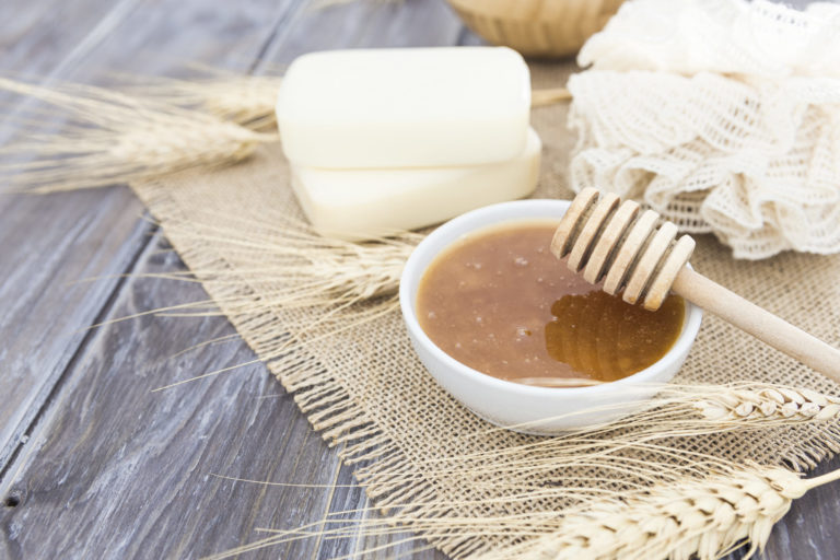 pote de mel com barras de sabão ao fundo